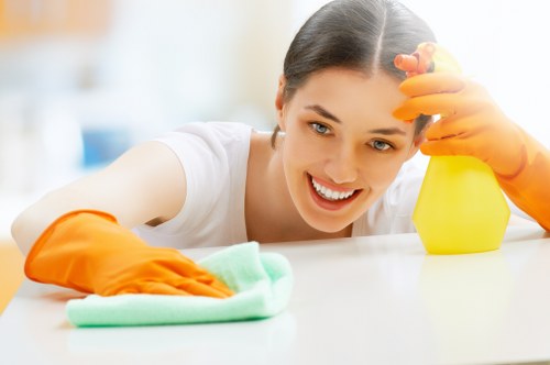 Professional cleaner preparing a tidy bedroom in E8