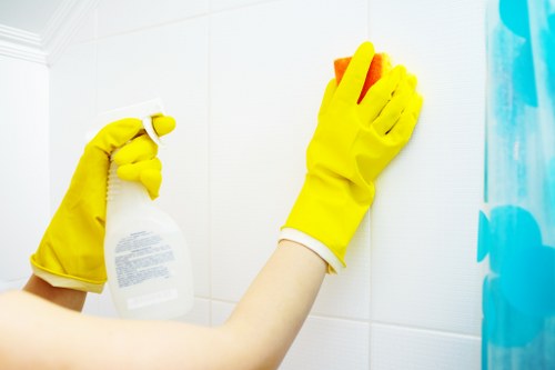 Local builders cleaning team removing dust from kitchen surfaces